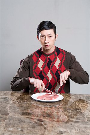 people eating raw meat - Young man cutting steak with knife and fork Stock Photo - Premium Royalty-Free, Code: 642-01735056