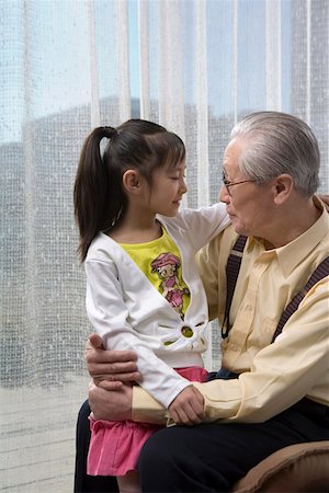 Granddaughter talking to grandfather, smiling Stock Photo - Premium Royalty-Free, Code: 642-01735117