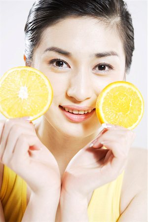 people with fruits cutout - Young woman holding lemon slices Stock Photo - Premium Royalty-Free, Code: 642-01735190