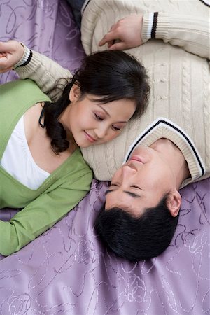 Jeune couple allongé sur le lit, souriant, vue aérienne Photographie de stock - Premium Libres de Droits, Code: 642-01735261