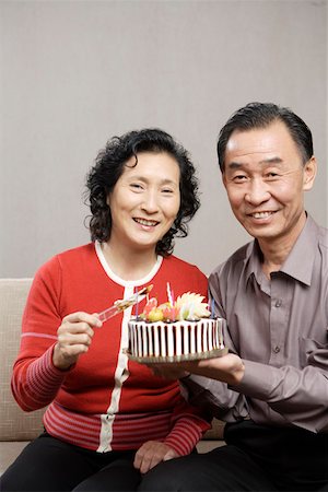 Senior couple sitting and holding cake Stock Photo - Premium Royalty-Free, Code: 642-01735350