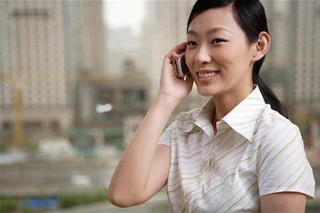 simsearch:642-01734897,k - Young businesswoman using mobile phone, smiling Stock Photo - Premium Royalty-Free, Code: 642-01735495