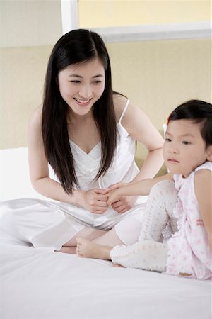 sad girl sitting cross legged - Mother looking at daughter and smiling Stock Photo - Premium Royalty-Free, Code: 642-01735569