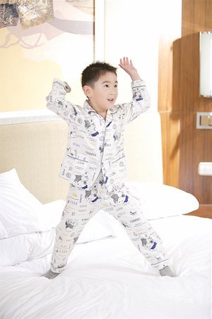 simsearch:642-01732852,k - Boy standing on bed with arms raised Stock Photo - Premium Royalty-Free, Code: 642-01735572