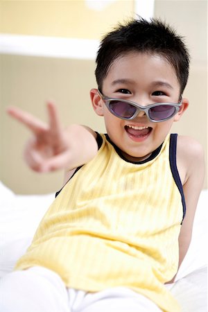 simsearch:642-01732852,k - Boy wearing sunglasses and sitting on bed, smiling Stock Photo - Premium Royalty-Free, Code: 642-01735588