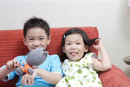 simsearch:642-01735584,k - Enfants assis sur le canapé avec des jouets, portrait, sourire Photographie de stock - Premium Libres de Droits, Code: 642-01735601