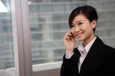 simsearch:642-01734897,k - Young businesswoman using mobile phone, smiling Stock Photo - Premium Royalty-Free, Code: 642-01735709