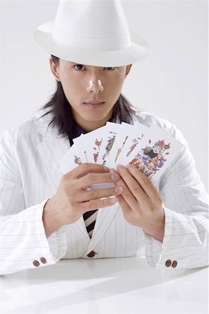 Young man sitting, playing with cards Foto de stock - Sin royalties Premium, Código: 642-01735785
