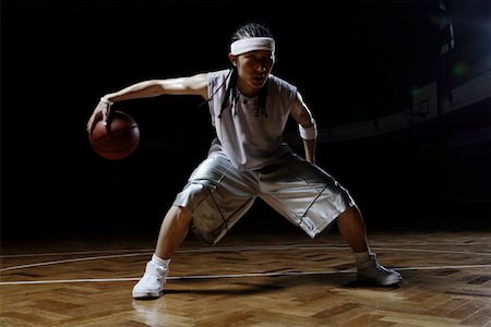 Basketball player dribbling ball on court Stock Photo - Premium Royalty-Free, Code: 642-01735927