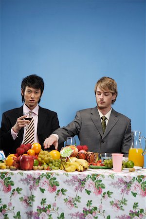 simsearch:642-01736411,k - Jeune homme assis près de la table avec des fruits et des boissons Photographie de stock - Premium Libres de Droits, Code: 642-01736277