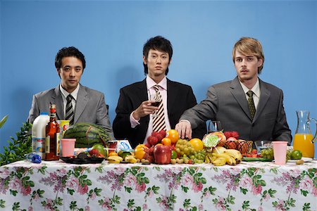 simsearch:642-01736431,k - Portrait d'un jeune hommes assis devant la table avec des fruits et des boissons Photographie de stock - Premium Libres de Droits, Code: 642-01736278