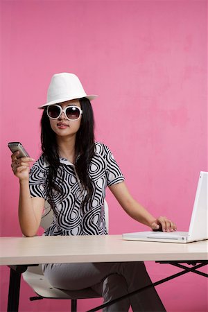 simsearch:642-01734897,k - Young woman holding mobile phone, using laptop Stock Photo - Premium Royalty-Free, Code: 642-01736315