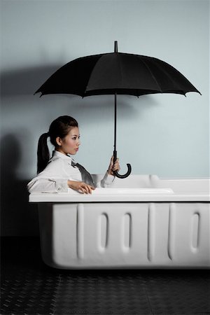 Young woman in bathtub sitting under umbrella Stock Photo - Premium Royalty-Free, Code: 642-01736367