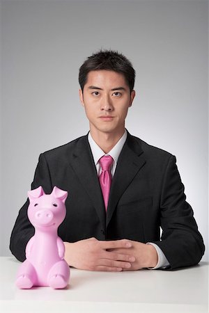 Young businessman sitting by toy Stock Photo - Premium Royalty-Free, Code: 642-01736403