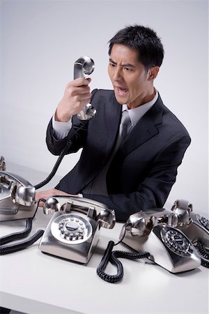 receiver - Businessman shouting in front of a telephone receiver Stock Photo - Premium Royalty-Free, Code: 642-01736421