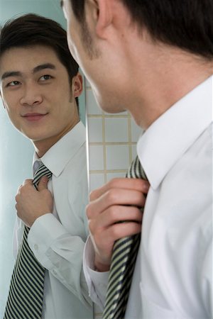 simsearch:642-01737076,k - Homme d'affaires, regarder dans le miroir et souriant Photographie de stock - Premium Libres de Droits, Code: 642-01736795