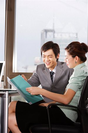 Businessman and a businesswoman looking at a file, discussing Stock Photo - Premium Royalty-Free, Code: 642-01736841