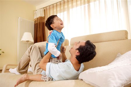 Father playing with son in sofa Foto de stock - Sin royalties Premium, Código: 642-01736927
