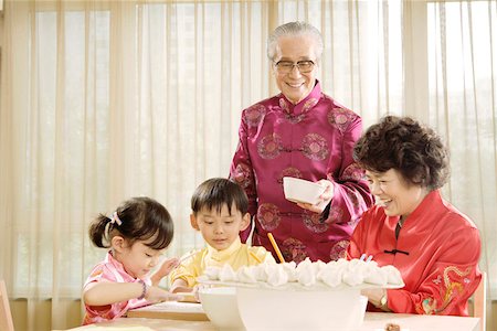 Seniors and juniors making dumplings Stock Photo - Premium Royalty-Free, Code: 642-01736958