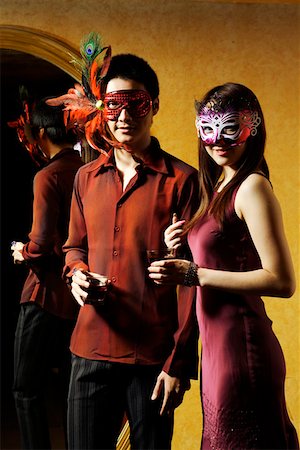 Young man and woman holding wineglass and wearing mask, portrait Stock Photo - Premium Royalty-Free, Code: 642-01737214