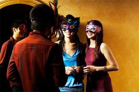 Young man and women holding wineglass and wearing mask Stock Photo - Premium Royalty-Free, Code: 642-01737240