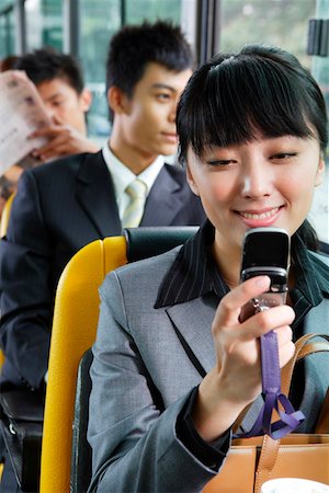 passenger inside bus - Young woman holding mobile phone, smiling Stock Photo - Premium Royalty-Free, Code: 642-01737259