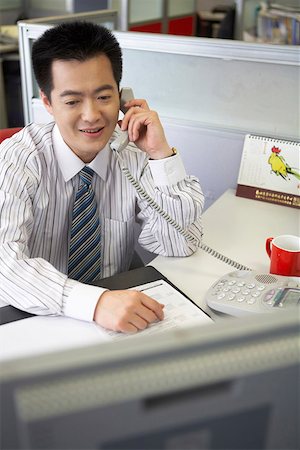 simsearch:642-01734721,k - Young businessman sitting in an office talking on the telephone Foto de stock - Royalty Free Premium, Número: 642-01737508