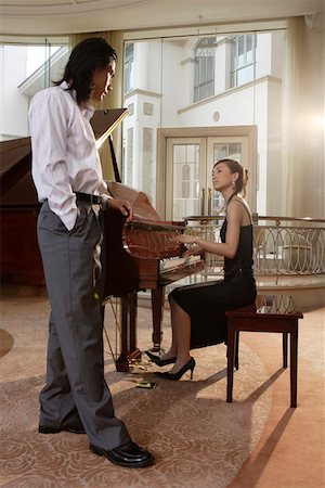 Young man standing near pianist in restaurant Stock Photo - Premium Royalty-Free, Code: 642-01737628