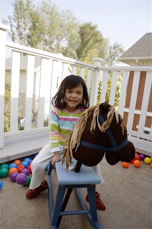 simsearch:642-01732733,k - Équitation de cheval à bascule, sourire, portrait de jeune fille Photographie de stock - Premium Libres de Droits, Code: 642-01732723