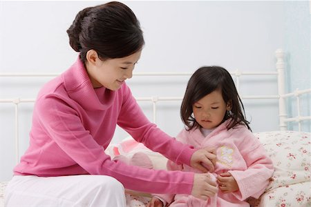 simsearch:642-01732733,k - Mother helping her daughter to wear a bathrobe in the bedroom Foto de stock - Royalty Free Premium, Número: 642-01732734