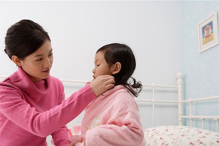 simsearch:642-01732733,k - Mother helping her daughter to wear a bathrobe in the bedroom Foto de stock - Royalty Free Premium, Número: 642-01732735