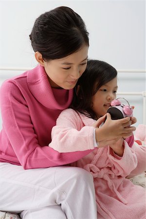 simsearch:642-01732733,k - Mother helping her daughter to set alarm on the timepiece Foto de stock - Royalty Free Premium, Número: 642-01732737