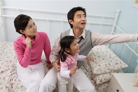 simsearch:642-01732733,k - Young couple playing with their daughter in the bedroom Foto de stock - Royalty Free Premium, Número: 642-01732751