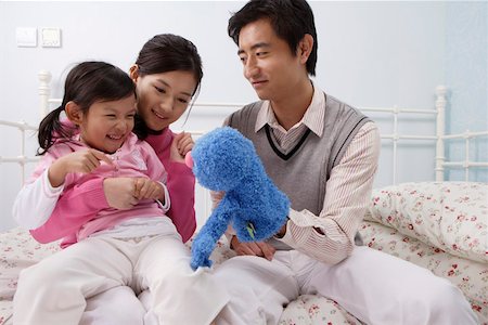 Family playing with a puppet in the bedroom Stock Photo - Premium Royalty-Free, Code: 642-01732761