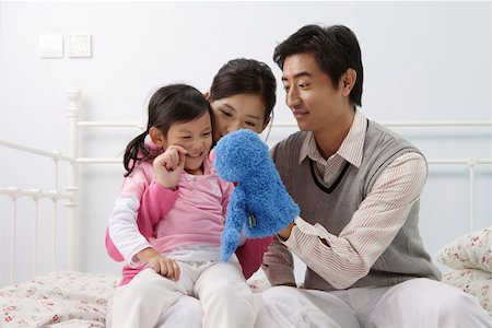 Family playing with a puppet in the bedroom Fotografie stock - Premium Royalty-Free, Codice: 642-01732763