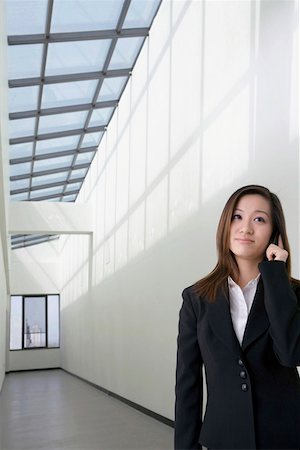 Young businesswoman using mobile phone, looking away Stock Photo - Premium Royalty-Free, Code: 642-01732792