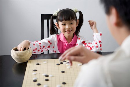 simsearch:642-01732733,k - Young man and daughter playing weiqi game board, smiling Foto de stock - Royalty Free Premium, Número: 642-01732846