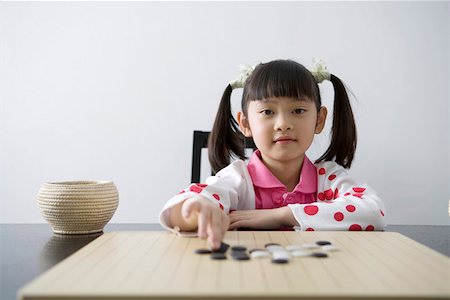 Girl playing weiqi game board, portrait Stock Photo - Premium Royalty-Free, Code: 642-01732843