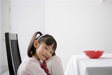 simsearch:642-01732852,k - Girl sitting on chair by dining table, smiling, portrait Stock Photo - Premium Royalty-Free, Code: 642-01732854