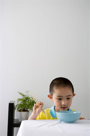 simsearch:642-01732733,k - Boy holding chopsticks at dining table, smiling Foto de stock - Royalty Free Premium, Número: 642-01732852