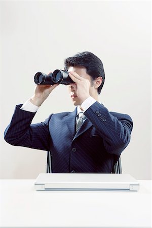 Businessman looking through binoculars Stock Photo - Premium Royalty-Free, Code: 642-01732899