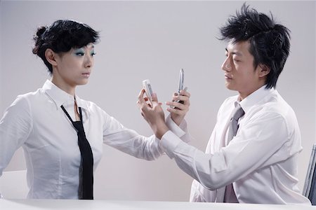 Young man and woman holding mobile phone Stock Photo - Premium Royalty-Free, Code: 642-01733036