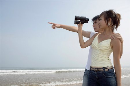 pointing horizon - Woman using binoculars, man pointing Stock Photo - Premium Royalty-Free, Code: 642-01733066