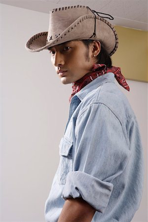 Close-up of a young man wearing cowboy hat Stock Photo - Premium Royalty-Free, Code: 642-01733188