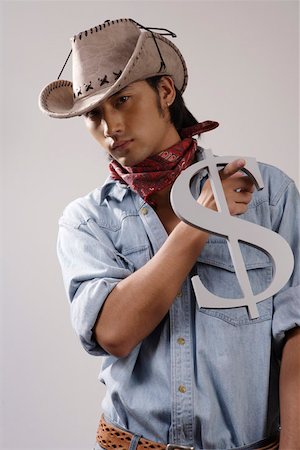 fashions cowboys for male - Close-up of a young man holding dollar sign Stock Photo - Premium Royalty-Free, Code: 642-01733190