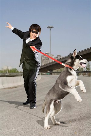 Man holding dog on an overpass Stock Photo - Premium Royalty-Free, Code: 642-01733302