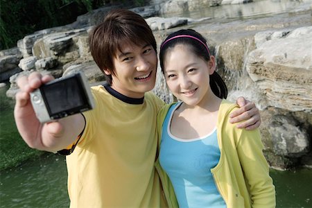 Young couple taking self portrait through digital camera Stock Photo - Premium Royalty-Free, Code: 642-01733338