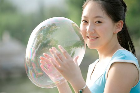 Jeune femme tenant des bulles, sourire, portrait Photographie de stock - Premium Libres de Droits, Code: 642-01733450