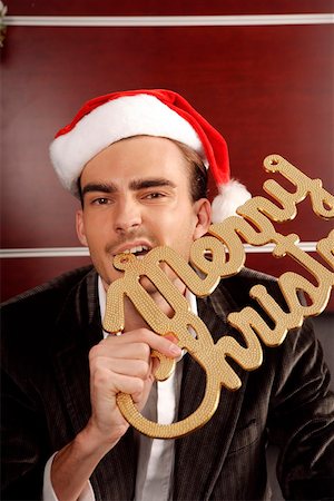 Young man biting sign of Merry Christmas Stock Photo - Premium Royalty-Free, Code: 642-01733490