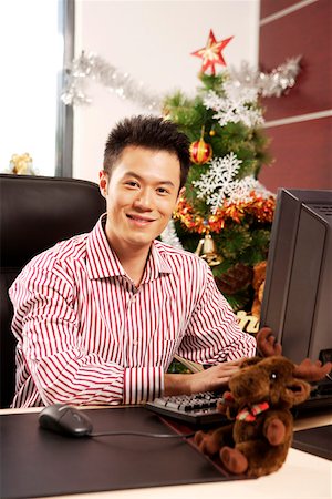 Portrait of young man sitting at desk in office, smiling Stock Photo - Premium Royalty-Free, Code: 642-01733512